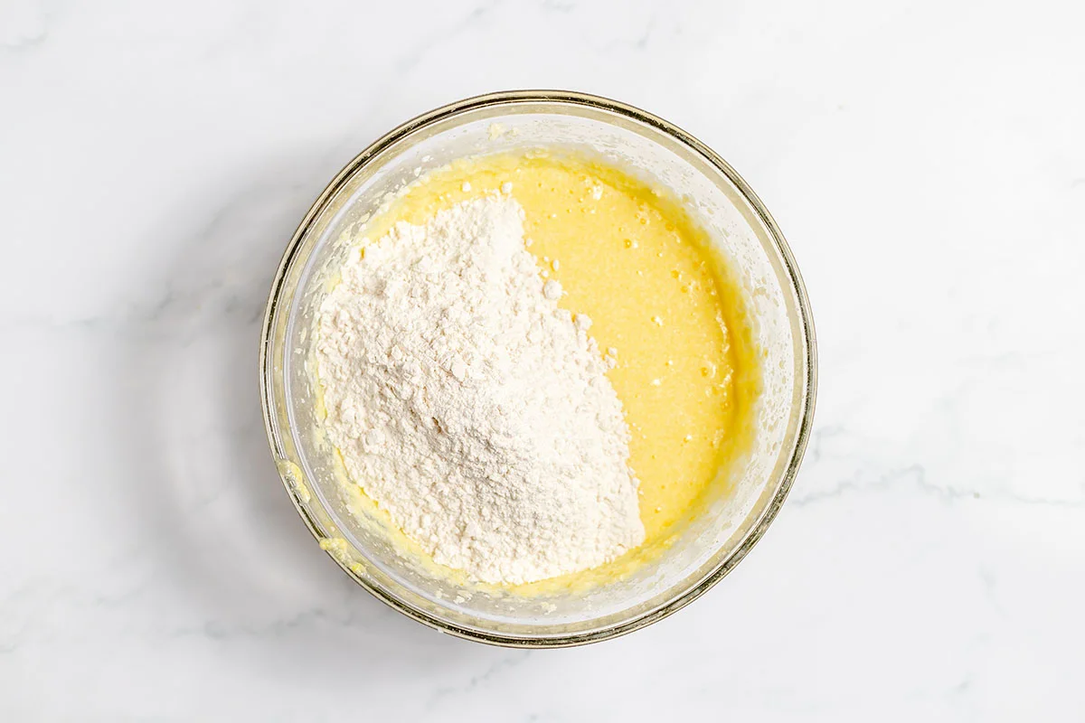 Flour added to wet ingredients in the mixing bowl.