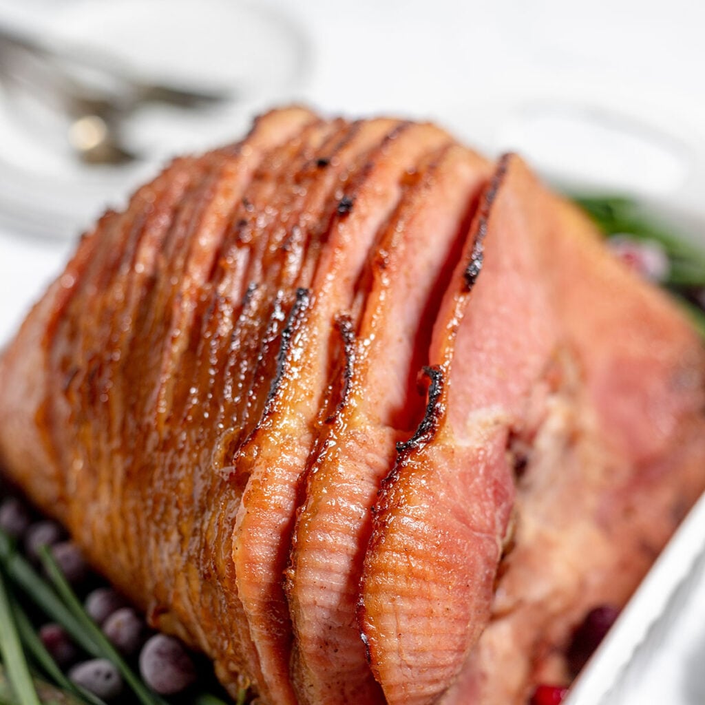 Spiral cut honey glazed ham in a baking dish.