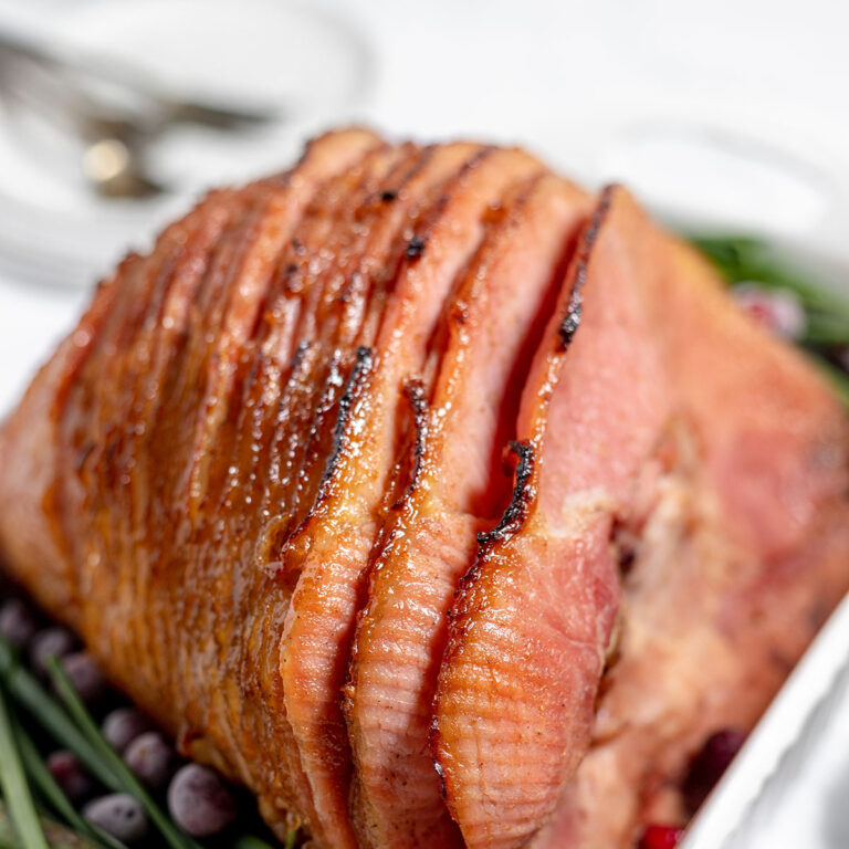 Spiral cut honey glazed ham in a baking dish.