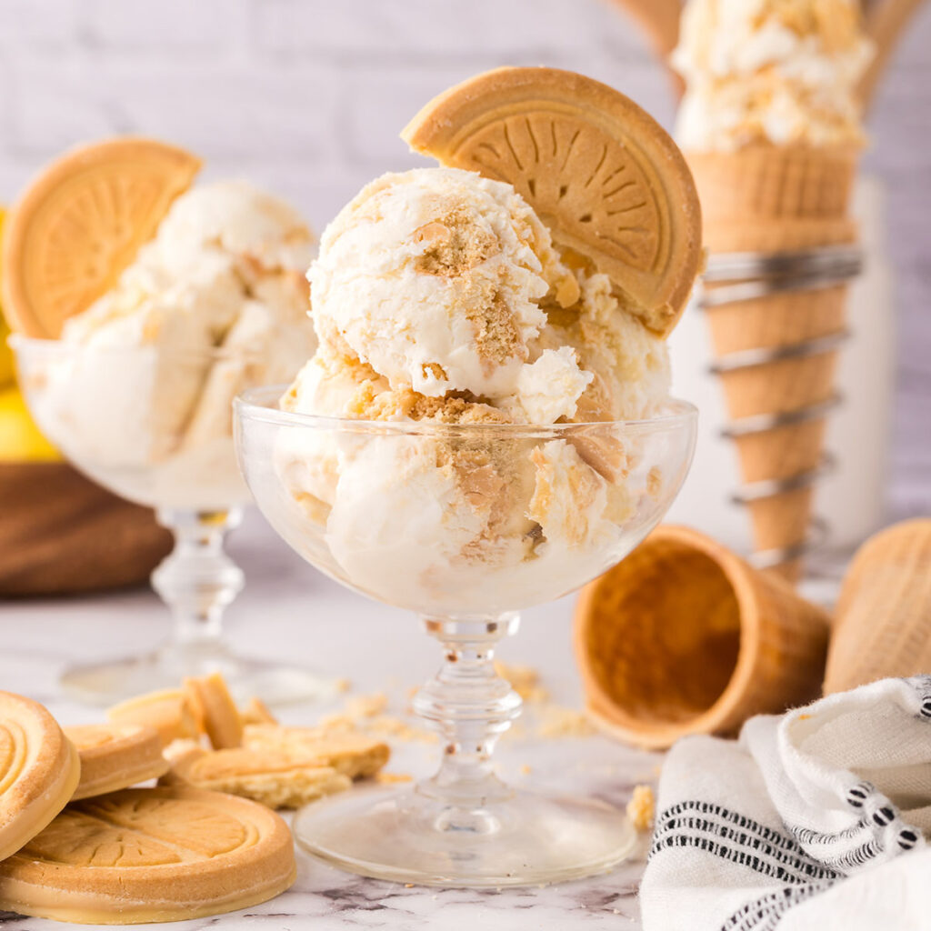 Scoops of lemon shortbread ice cream in a glass dessert bowl.