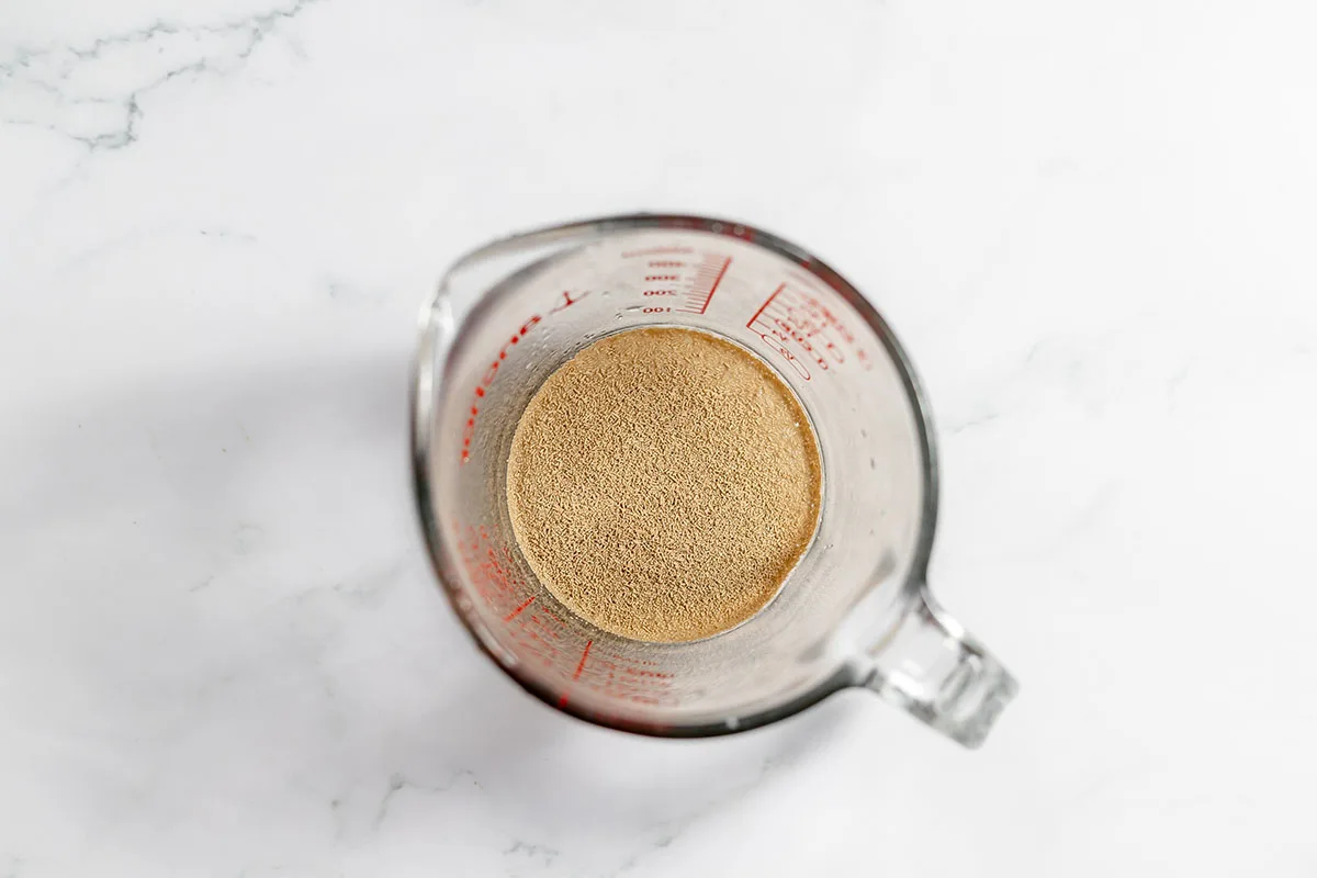 A packet of active dry yeast in a measuring bowl.