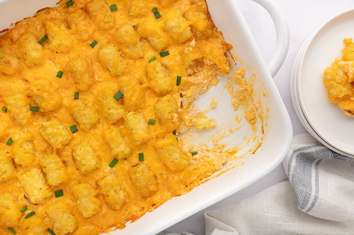 Baked Buffalo Chicken Tater Tot Casserole in a baking dish with a serving scooped out.
