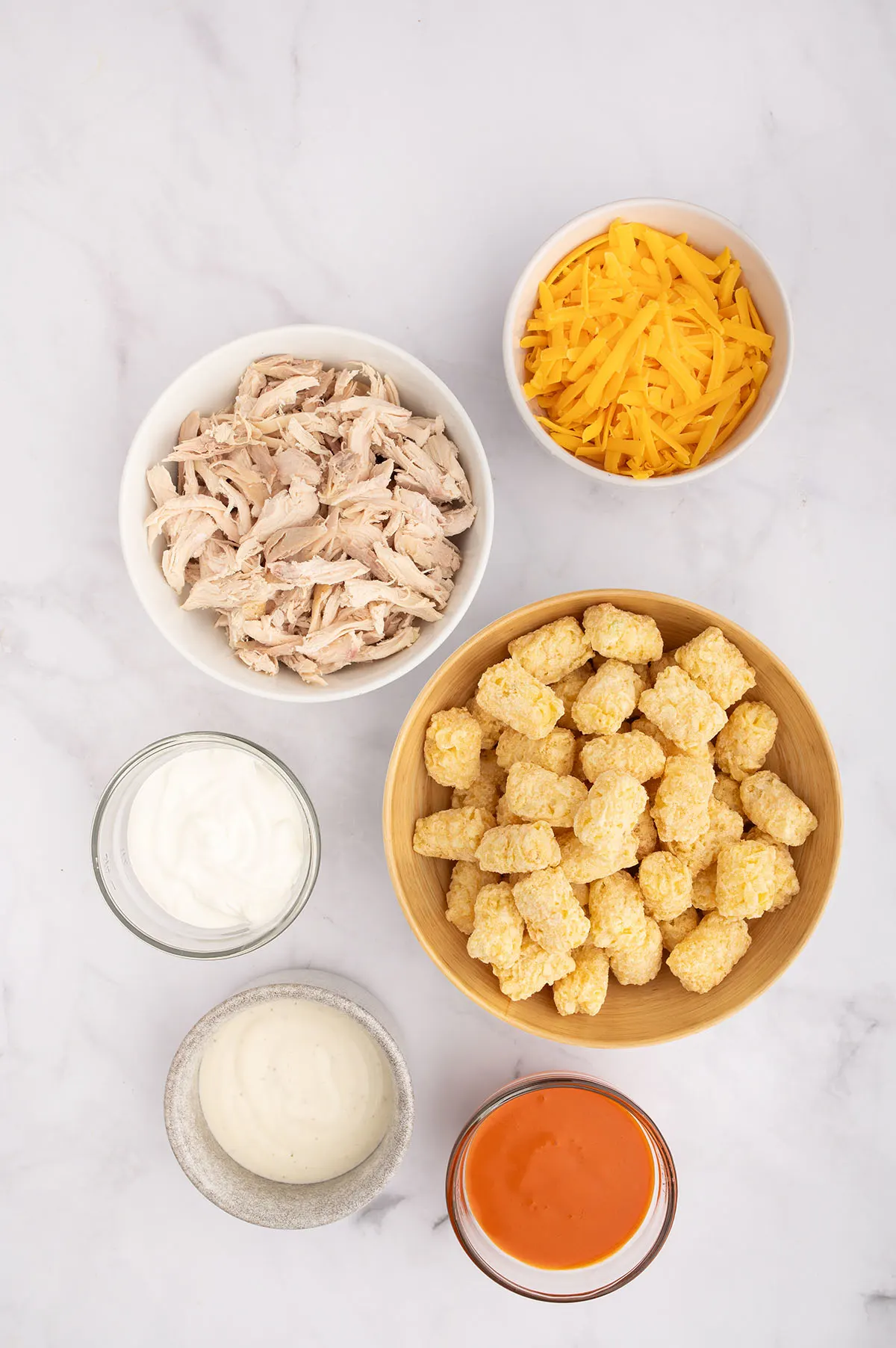 Ingredients to make Buffalo Chicken Tater Tot Casserole set out on the counter.