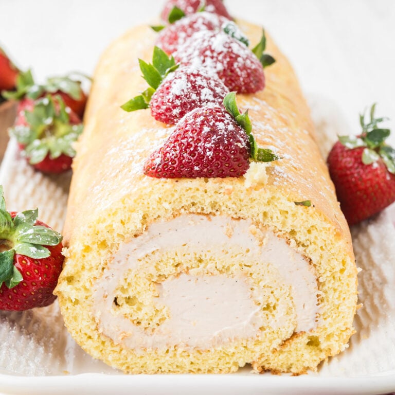 Strawberry Swiss Roll on a white serving platter.