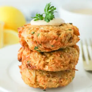 Three Crab Cakes stacked on a white plate.