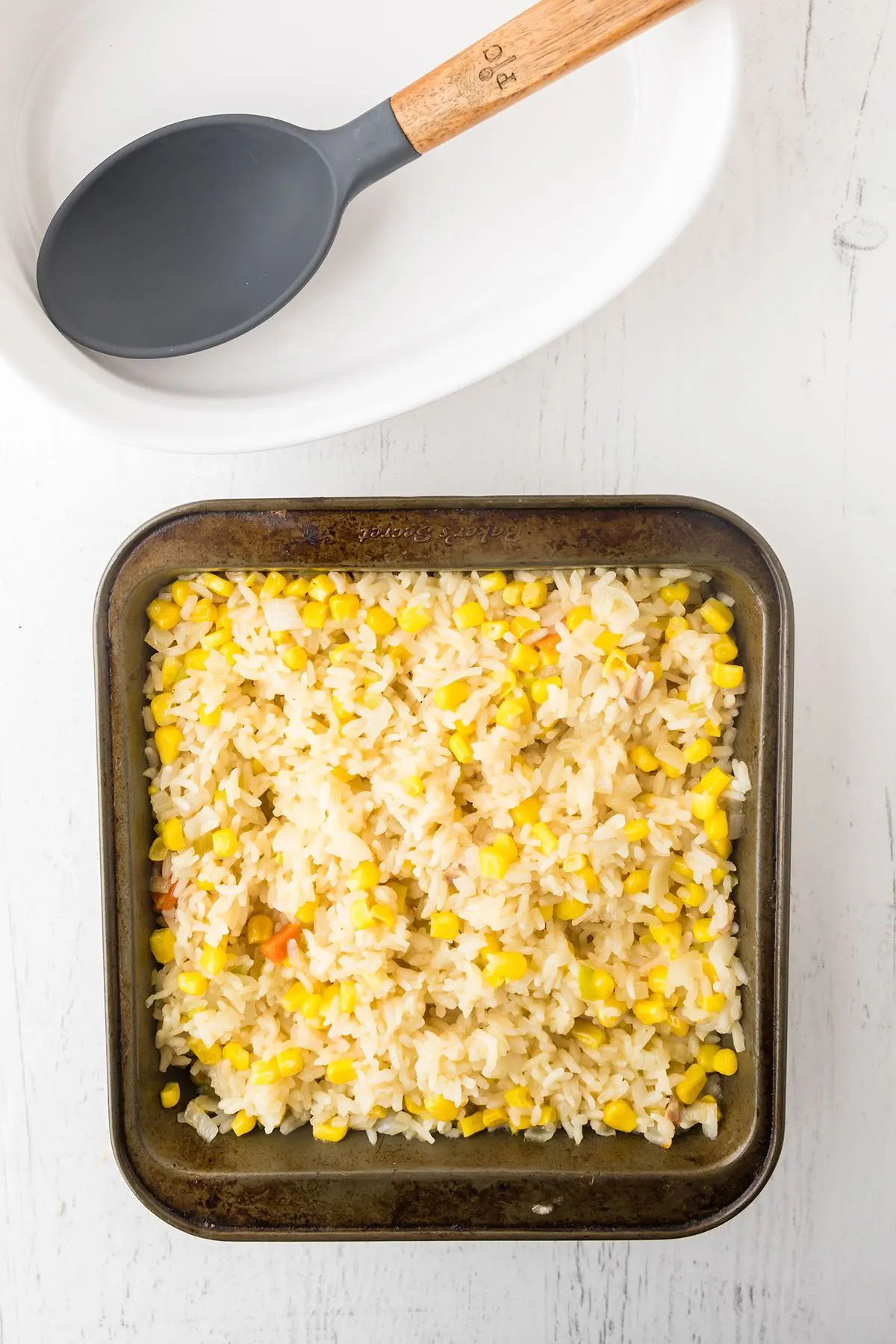 Corn Rice baked in a square metal baking pan.