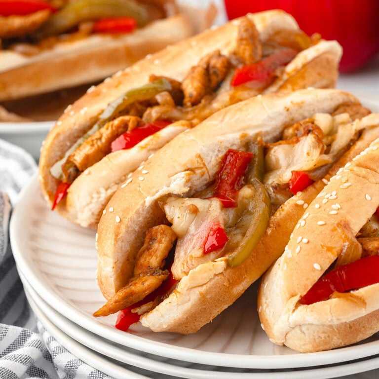 Three Chicken Philly Cheesesteak Sandwiches on a white plate.