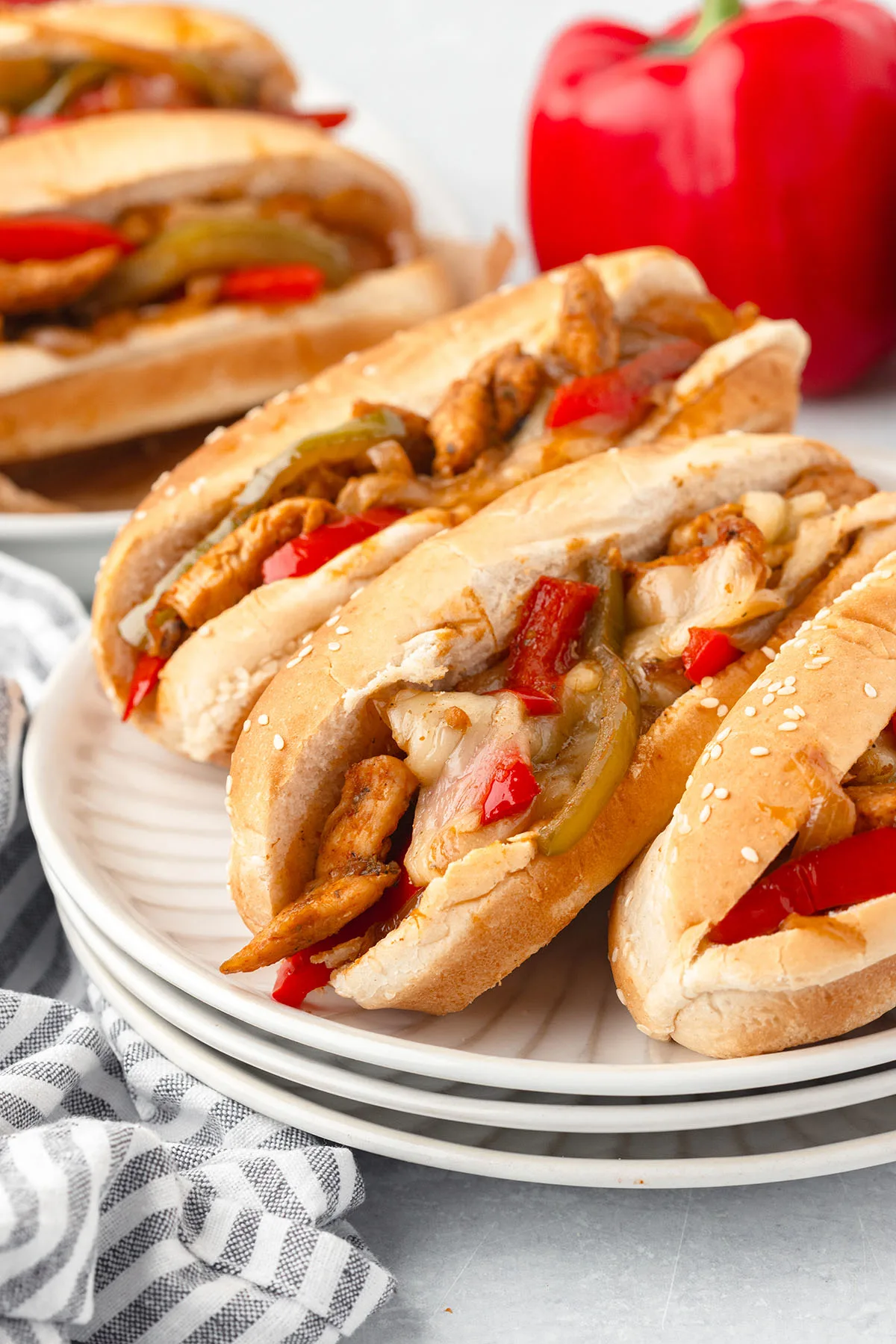 Three Chicken Philly Sandwiches served on a white plate.