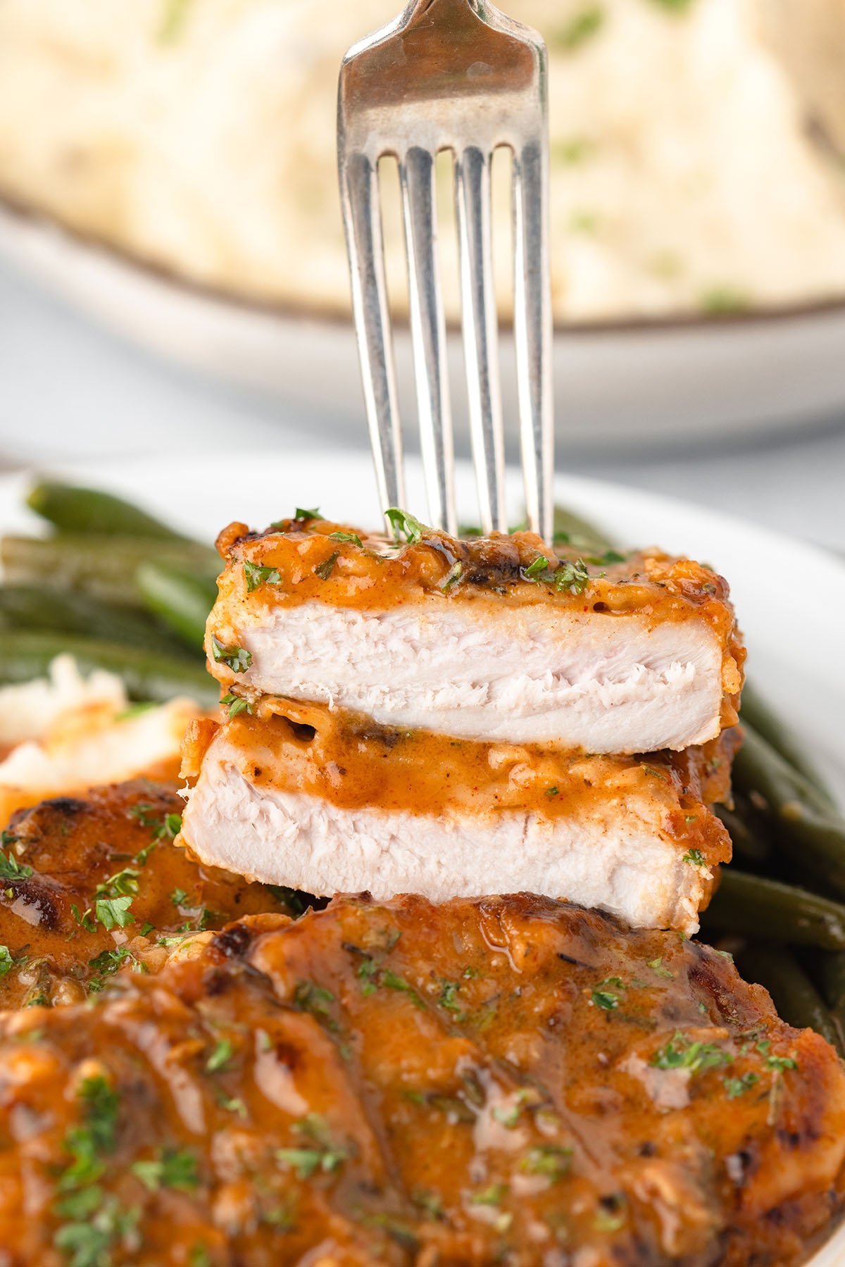 A fork with bites of Pork Chop.