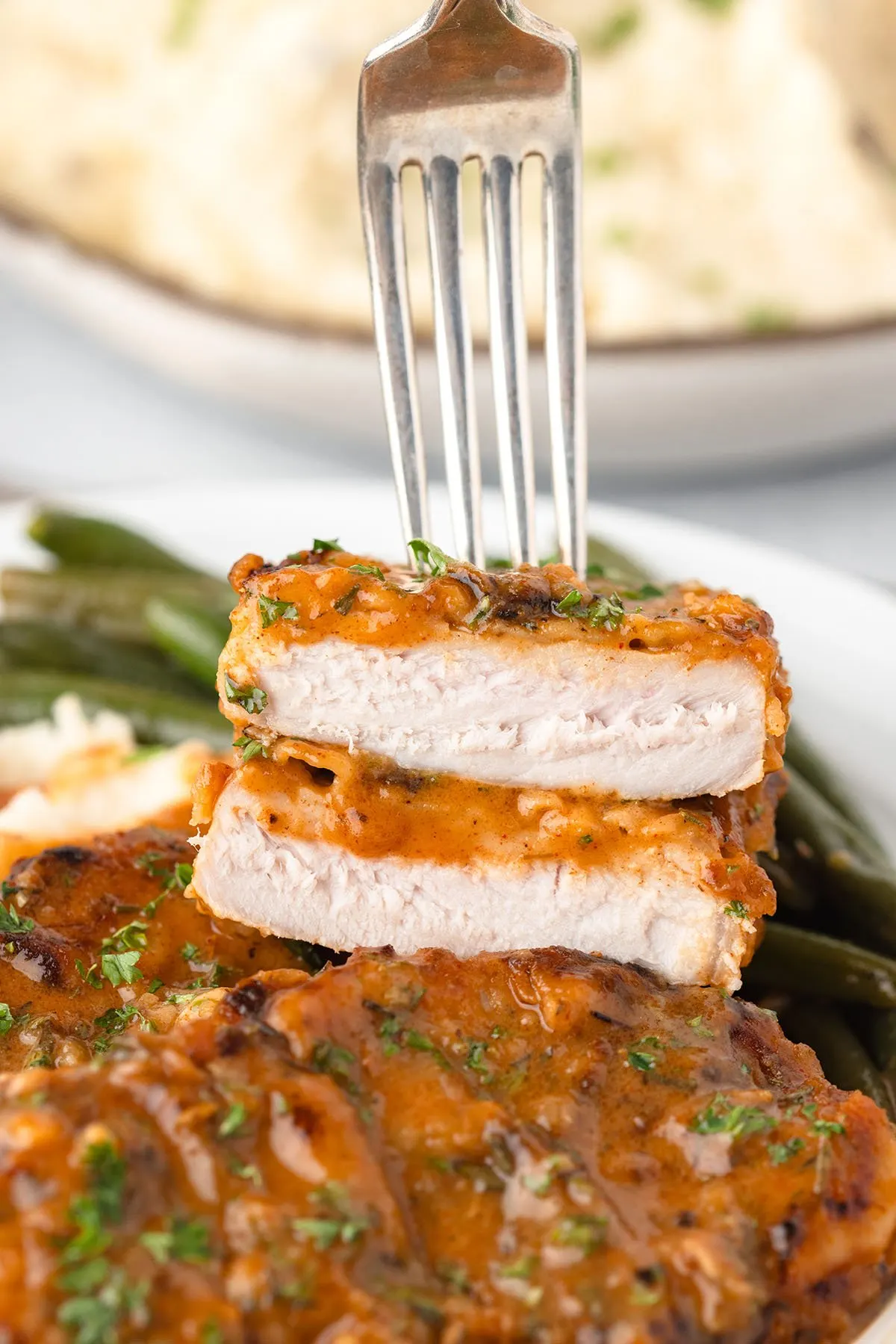 A fork with bites of Pork Chop.