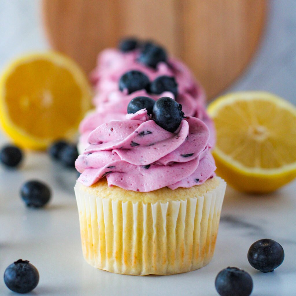 Lemon Cupcakes with Blueberry Buttercream set out on the counter.
