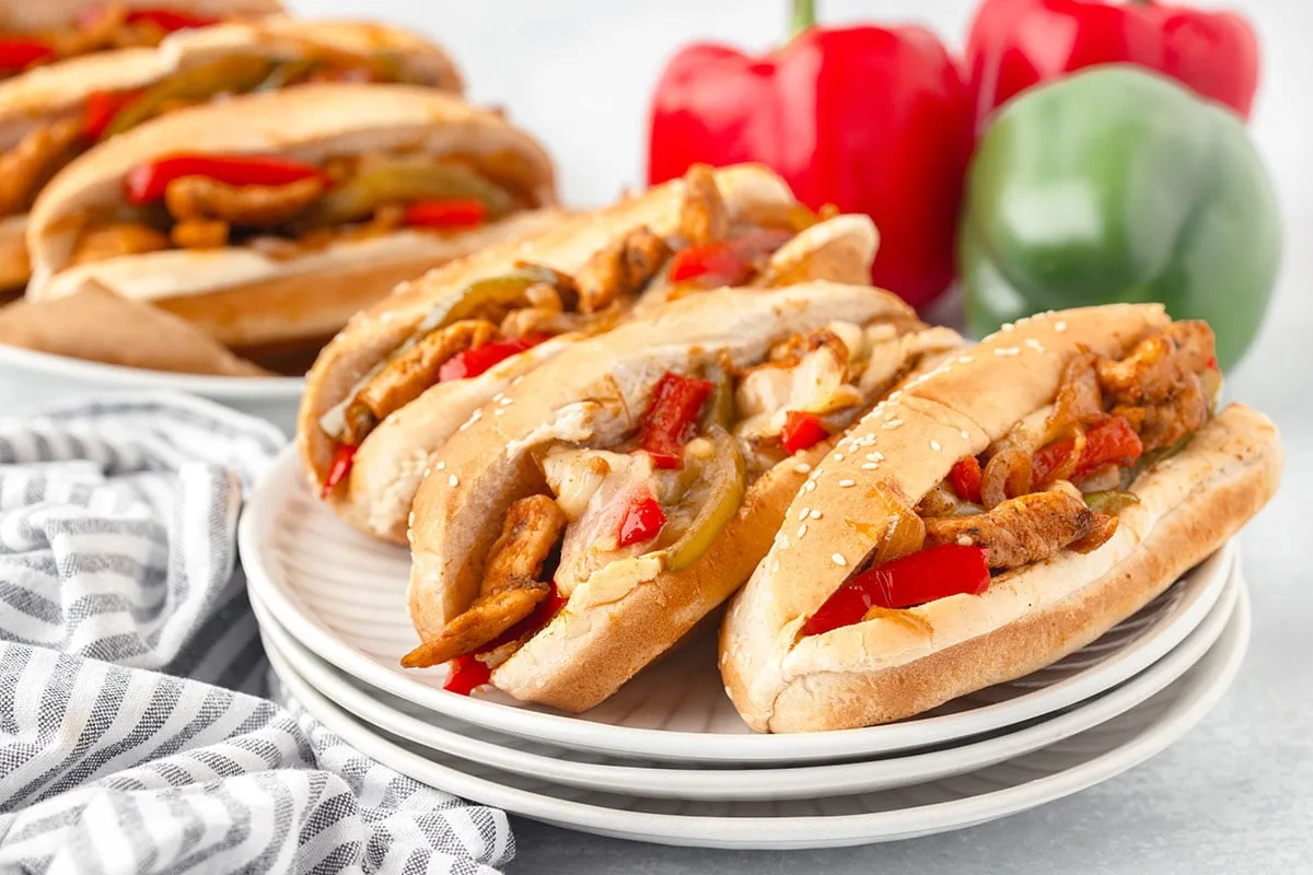 Chicken Philly cheesesteak sandwiches on a white plate.