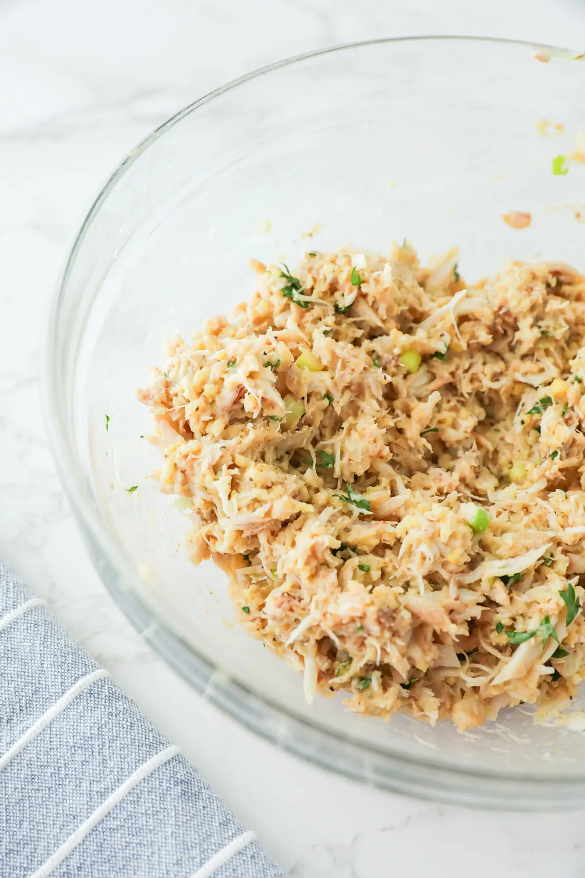 Crab cake mixture combined in a mixing bowl.