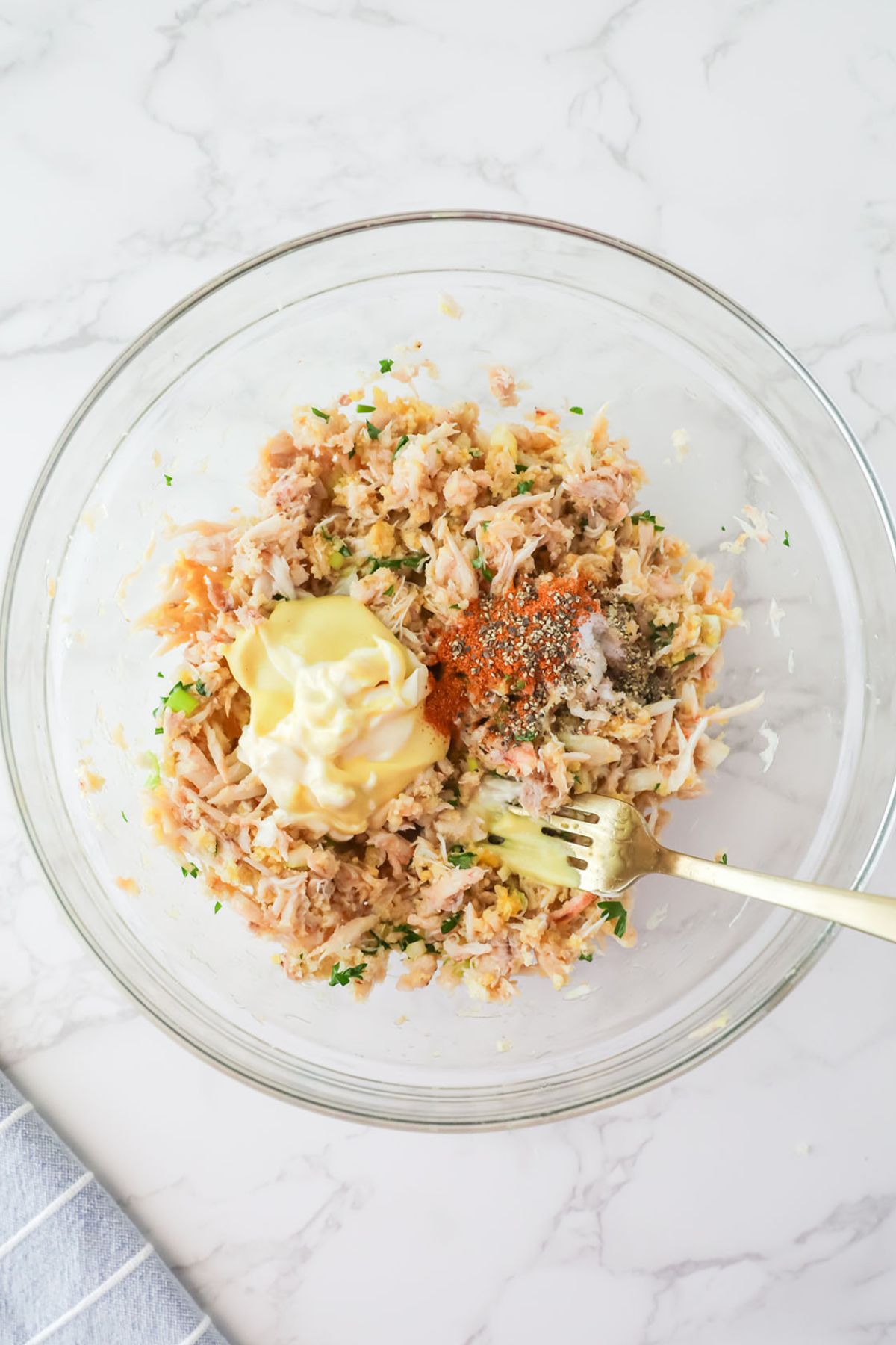 Mayonnaise, Dijon mustard, Old Bay seasoning, salt and pepper added to crab mixture in the mixing bowl.