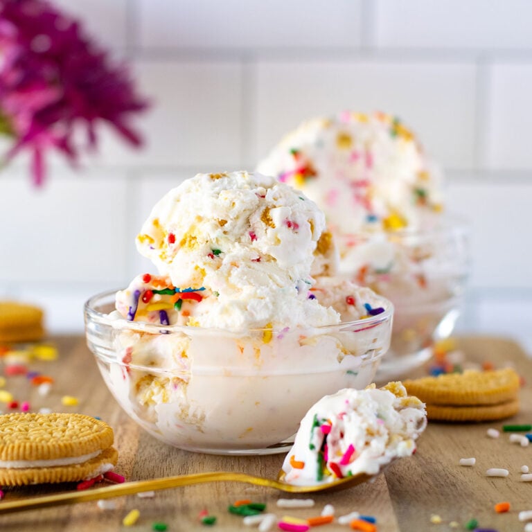 A scoop of Funfetti Golden Oreo Ice Cream in a glass dessert bowl.