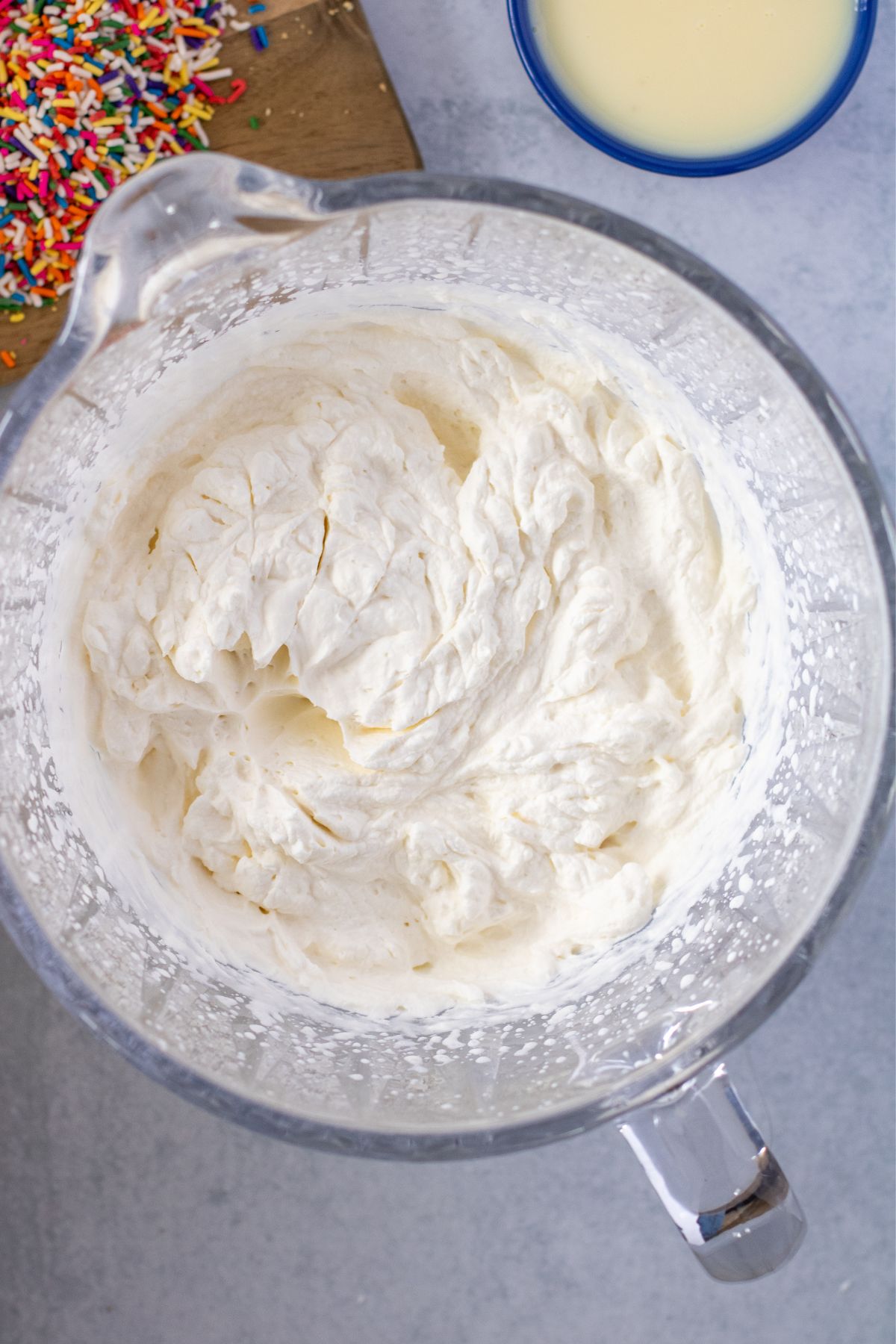 Heavy cream and vanilla beat together in a mixing bowl into stiff peaks.