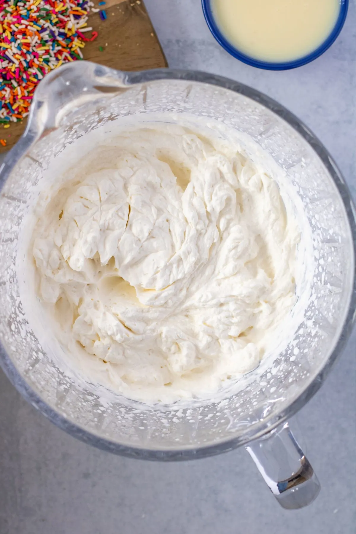 Heavy cream and vanilla beat together in a mixing bowl into stiff peaks.