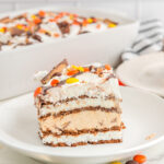 A slice of Reese's ice cream sandwich cake on a white plate.