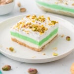 A slice of pistachio dessert on a white plate.