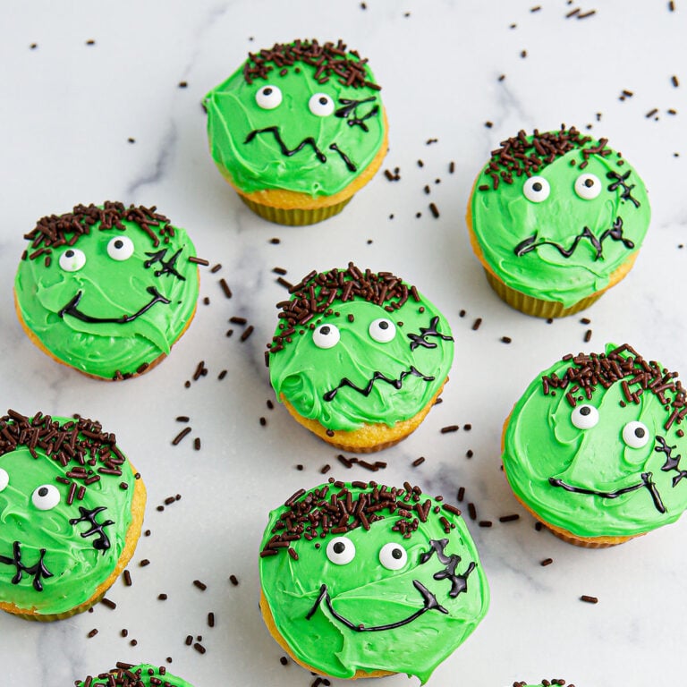Decorated Frankenstein cupcakes on the counter.