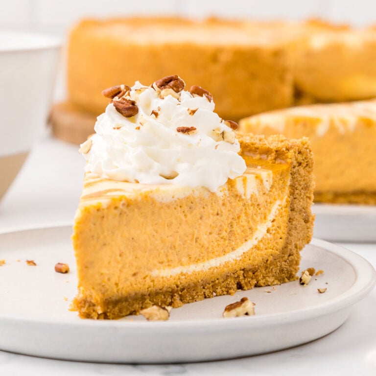 A slice of Pumpkin Swirl Cheesecake on a white plate.