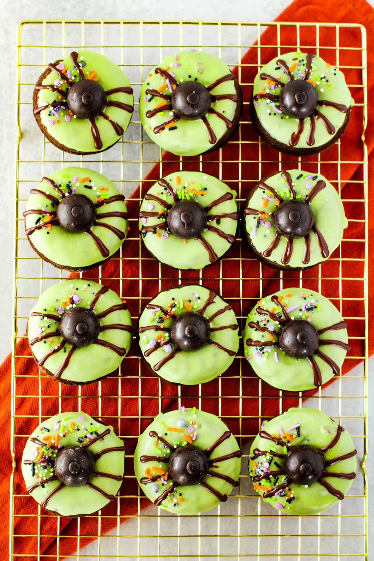 Decorated Spider donuts on a wire rack.