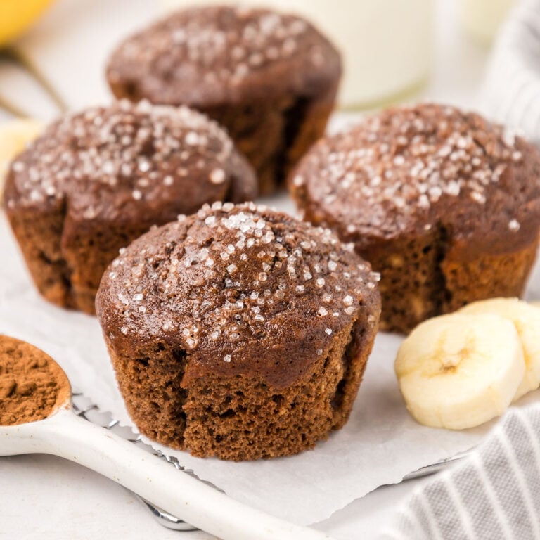 Chocolate Banana Muffins on parchment paper lined wire rack.