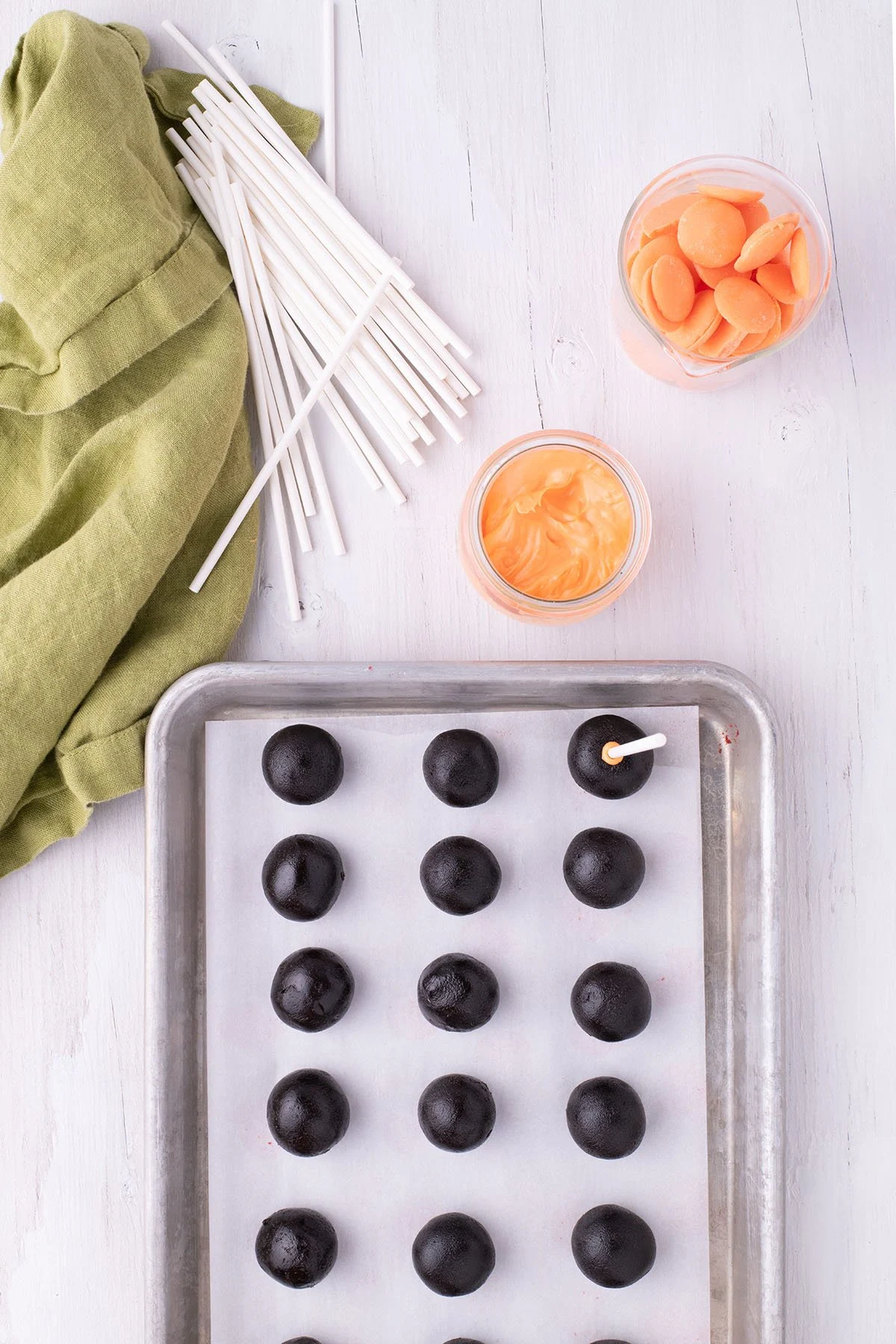 Cake pop balls on a parchment lined baking sheet.