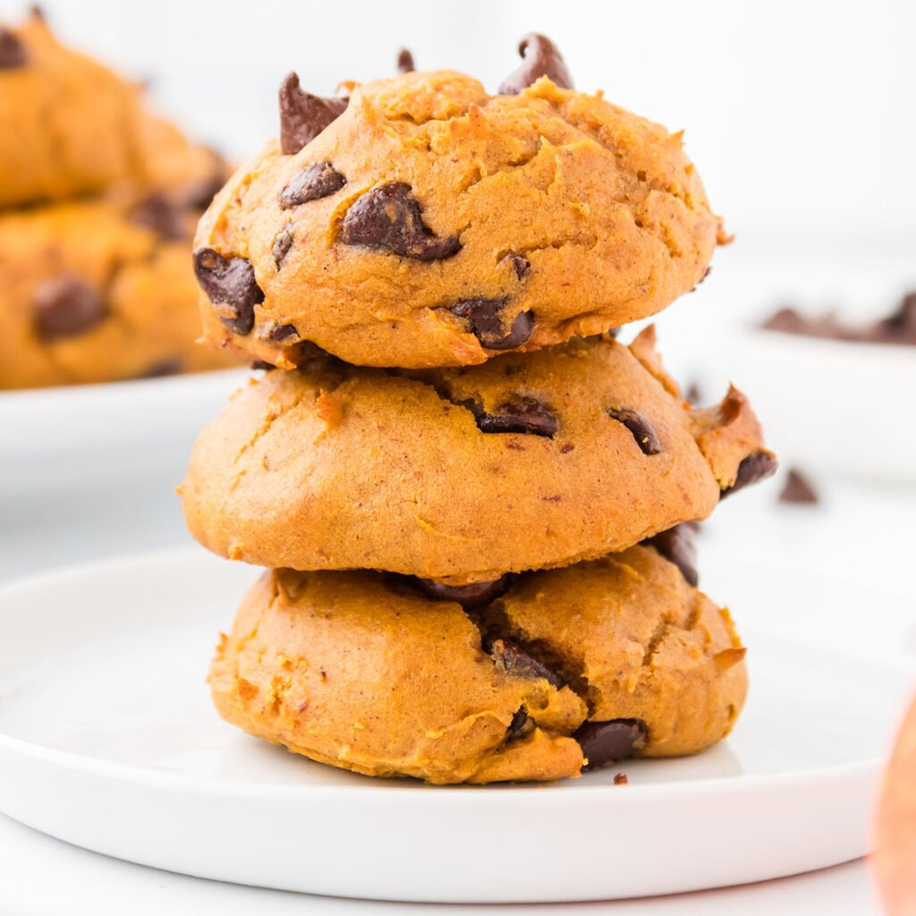 Three Spice cake pumpkin cookies stacked on a white plate.