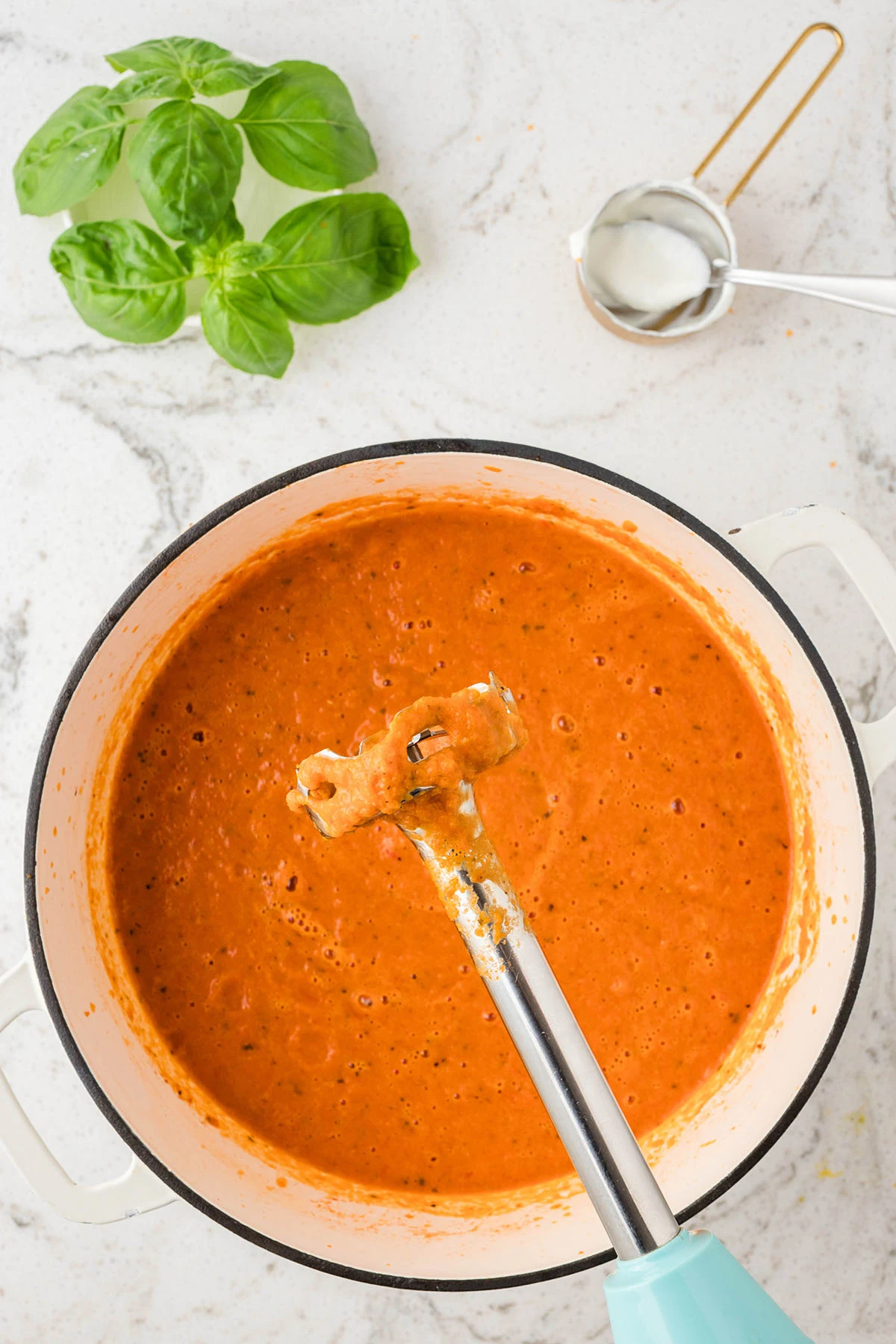 Blending soup in large pot with an immersion blender in large pot.