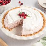 Cranberry Cream Pie in a white pie dish with a slice missing.