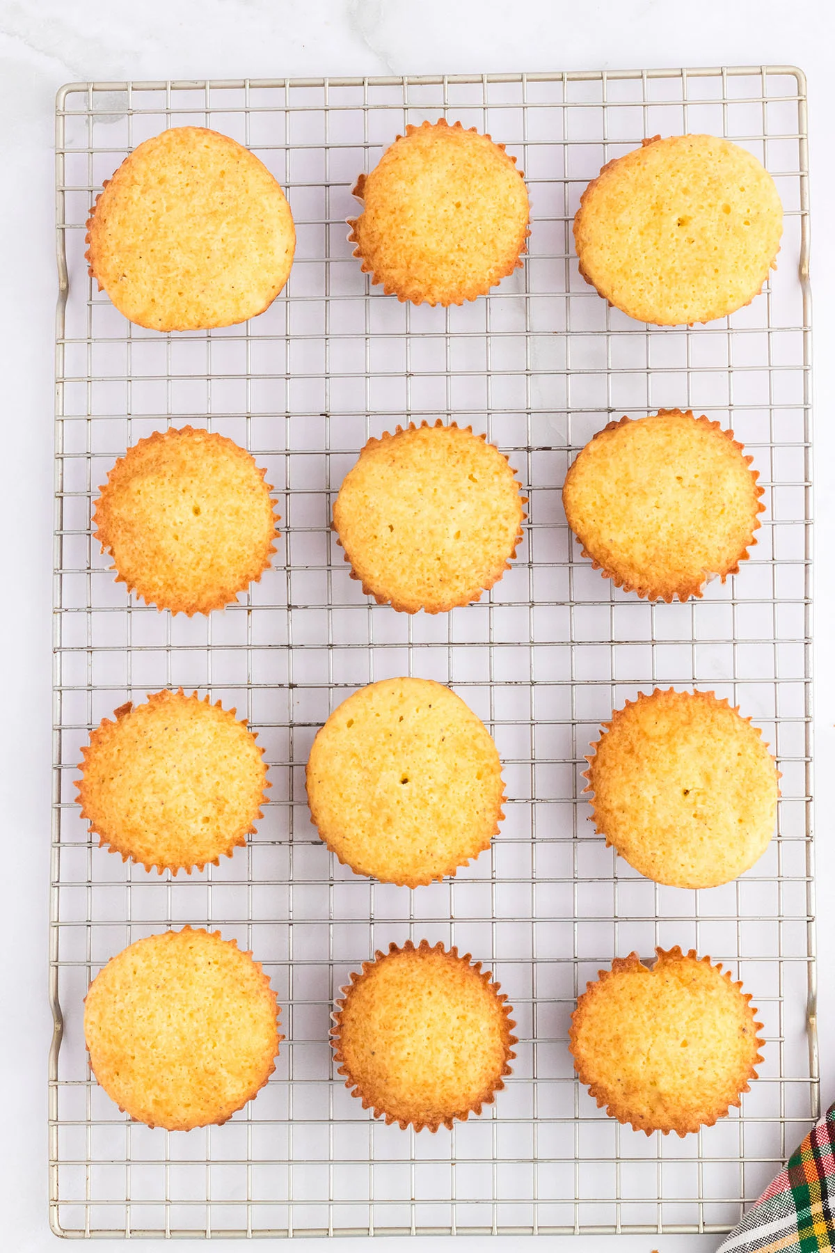 Eggnog cupcakes cooling on a wire rack.