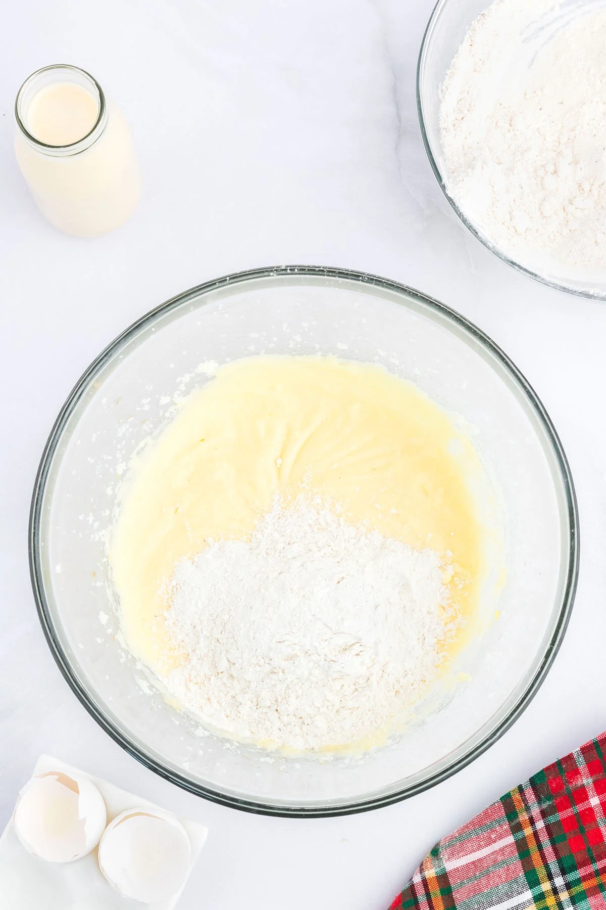 Flour added to cupcake batter in the glass mixing bowl.