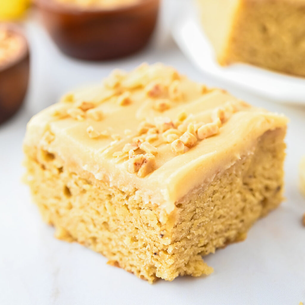 Banana Blondie topped with frosting and chopped nuts.