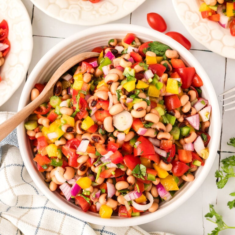 Black Eye Pea Salad served in a white bowl with a wooden spoon.