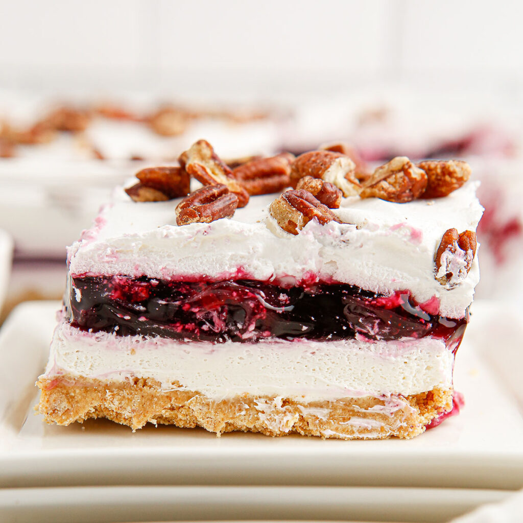 A slice of Blueberry Delight on a white plate.
