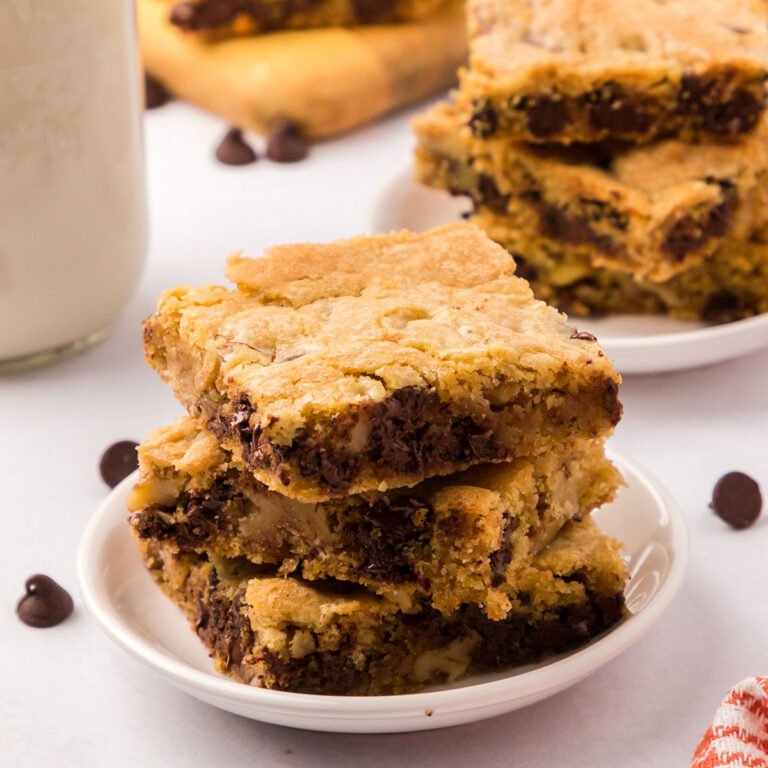 Chocolate Chip Cookie Bars stacked on a white plate.