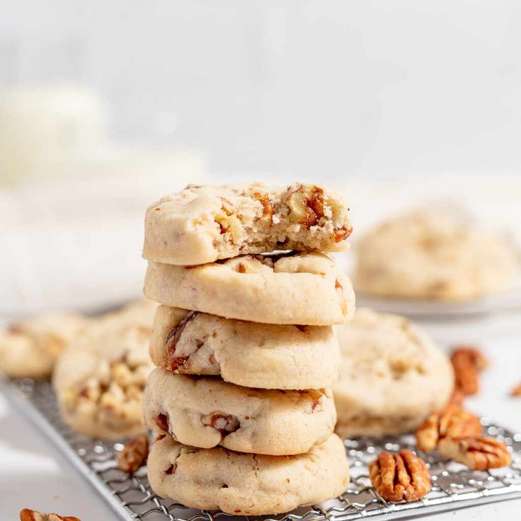 Pecan Shortbread Cookies stacked on a wire rack.