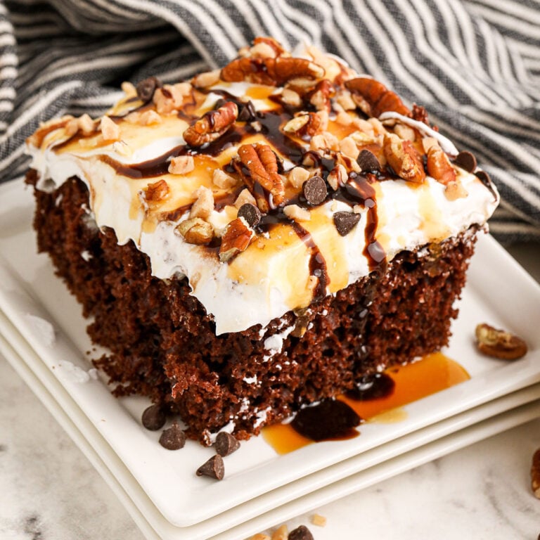 A slice of Turtle Poke Cake on a white plate.