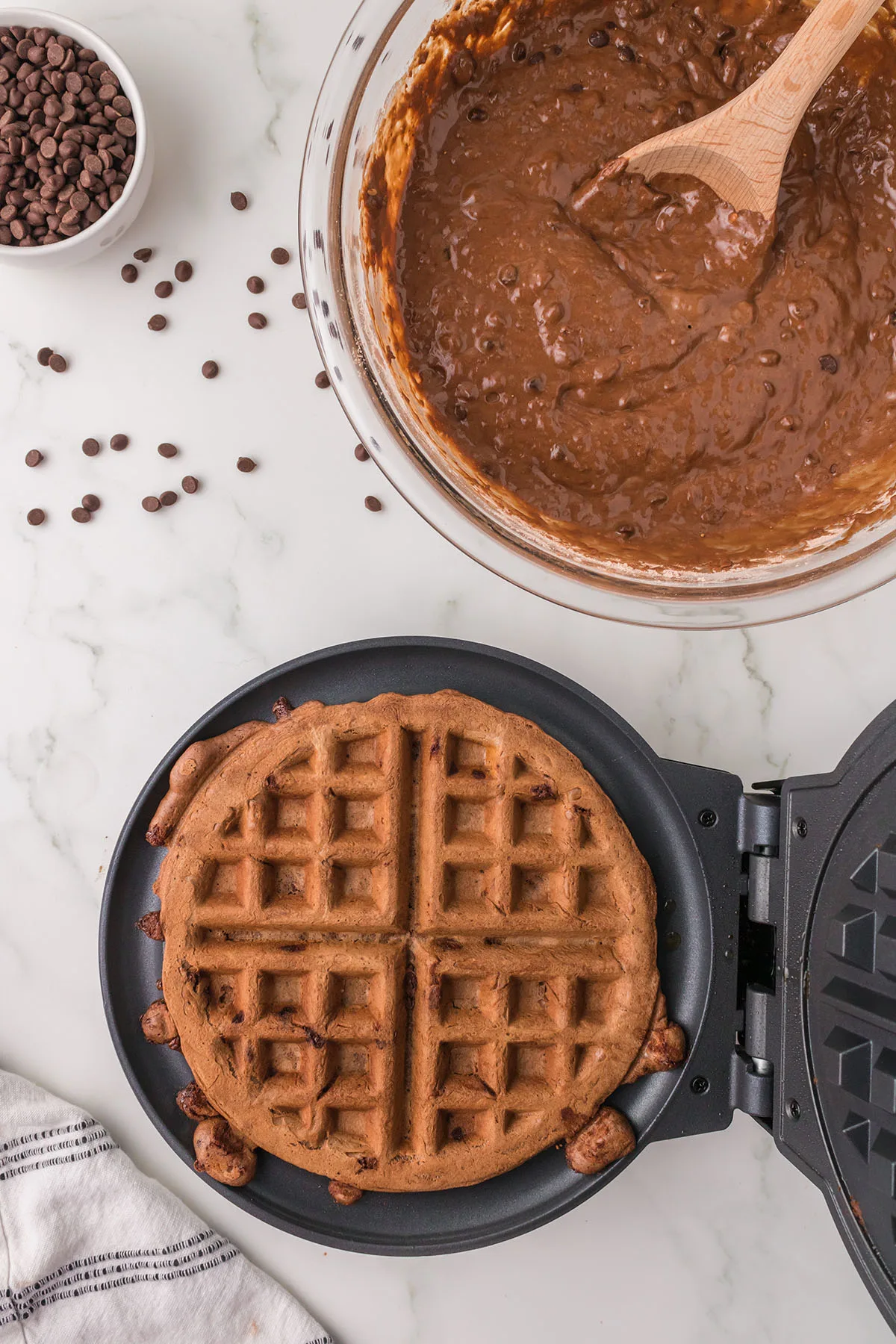A cooked chocolate waffle in the waffle maker.