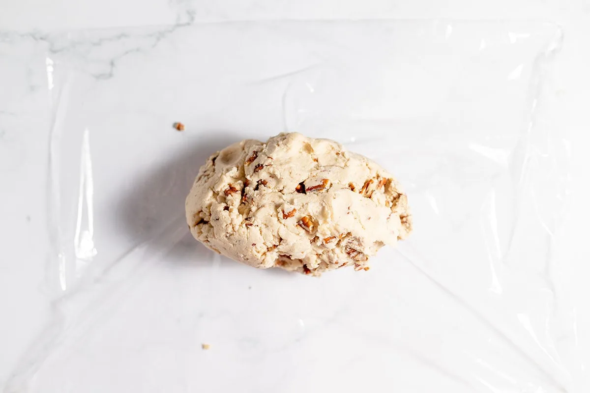 Pecan Shortbread Cookie dough placed on plastic wrap on the counter.