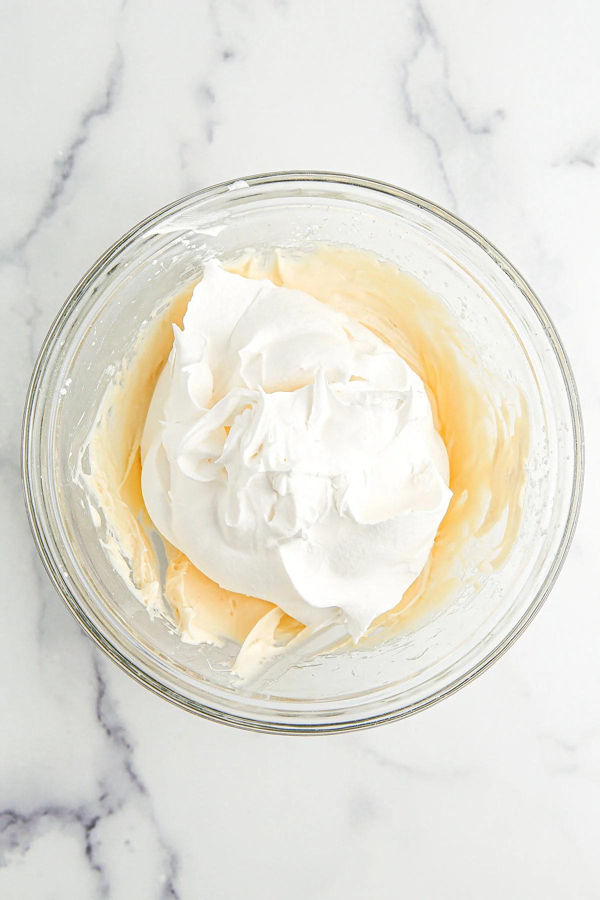 Whipped topping added to the cream cheese mixture in the mixing bowl.