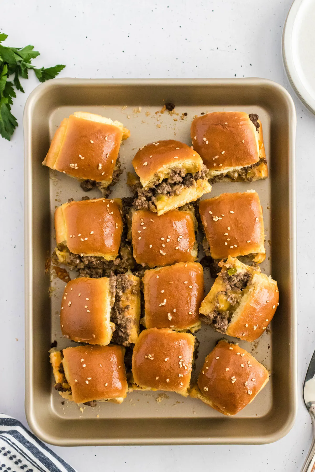 Baked cheeseburger sliders on a baking pan.