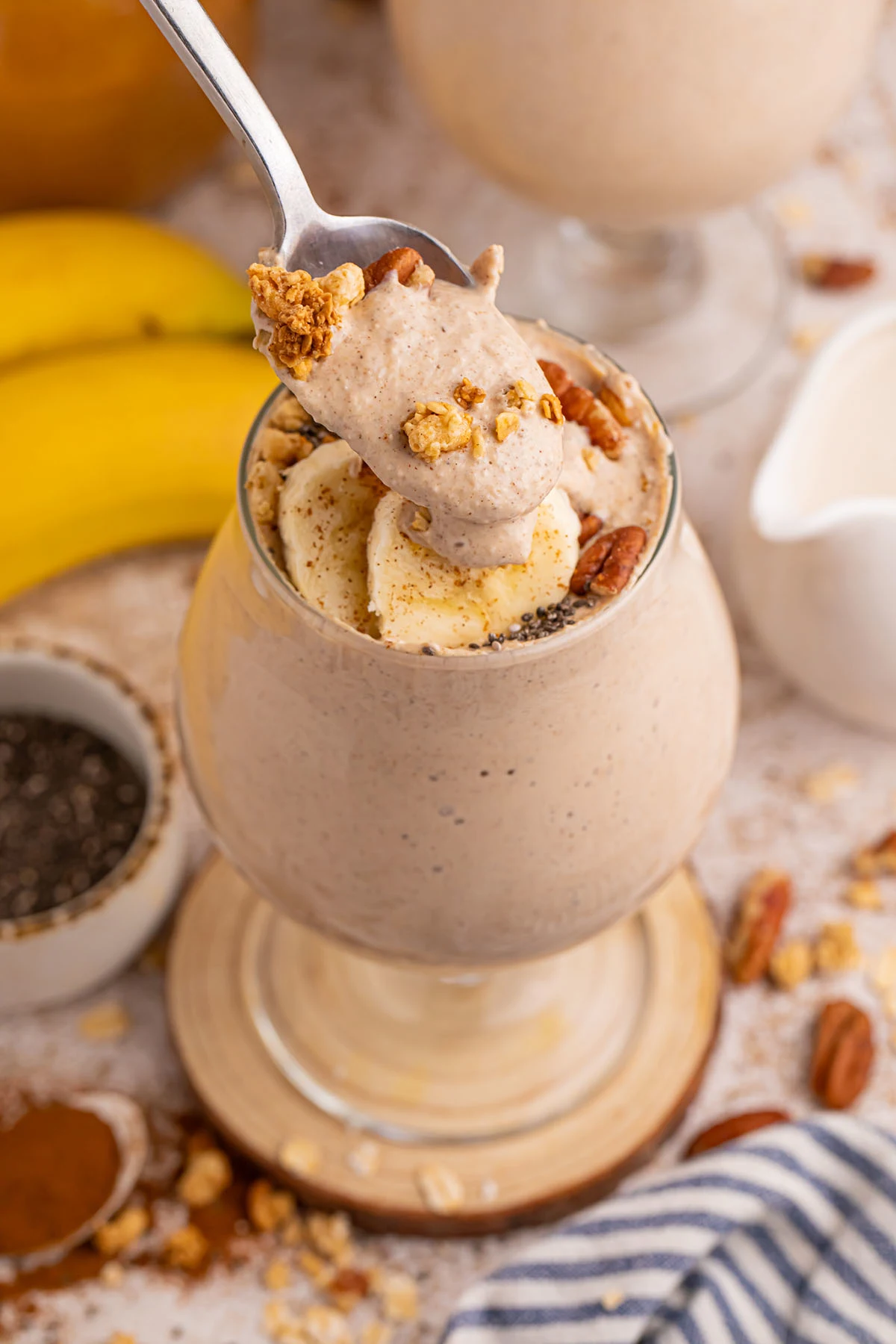 Banana Smoothie in a stemmed glass with a bite on a spoon.