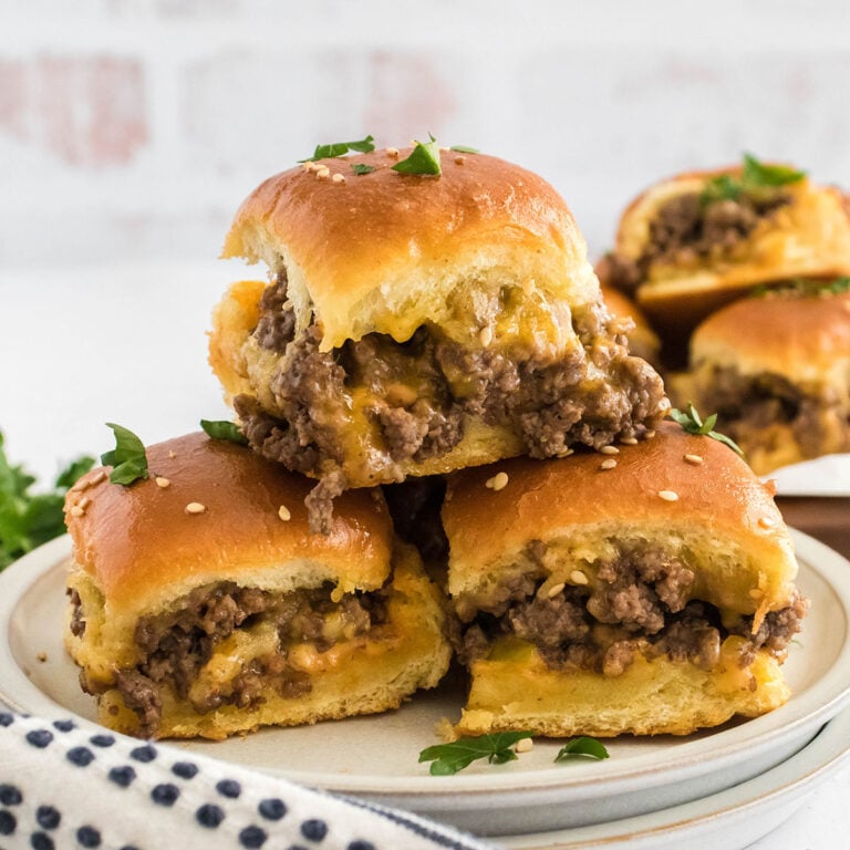 Three Cheeseburger Sliders stacked on a plate.