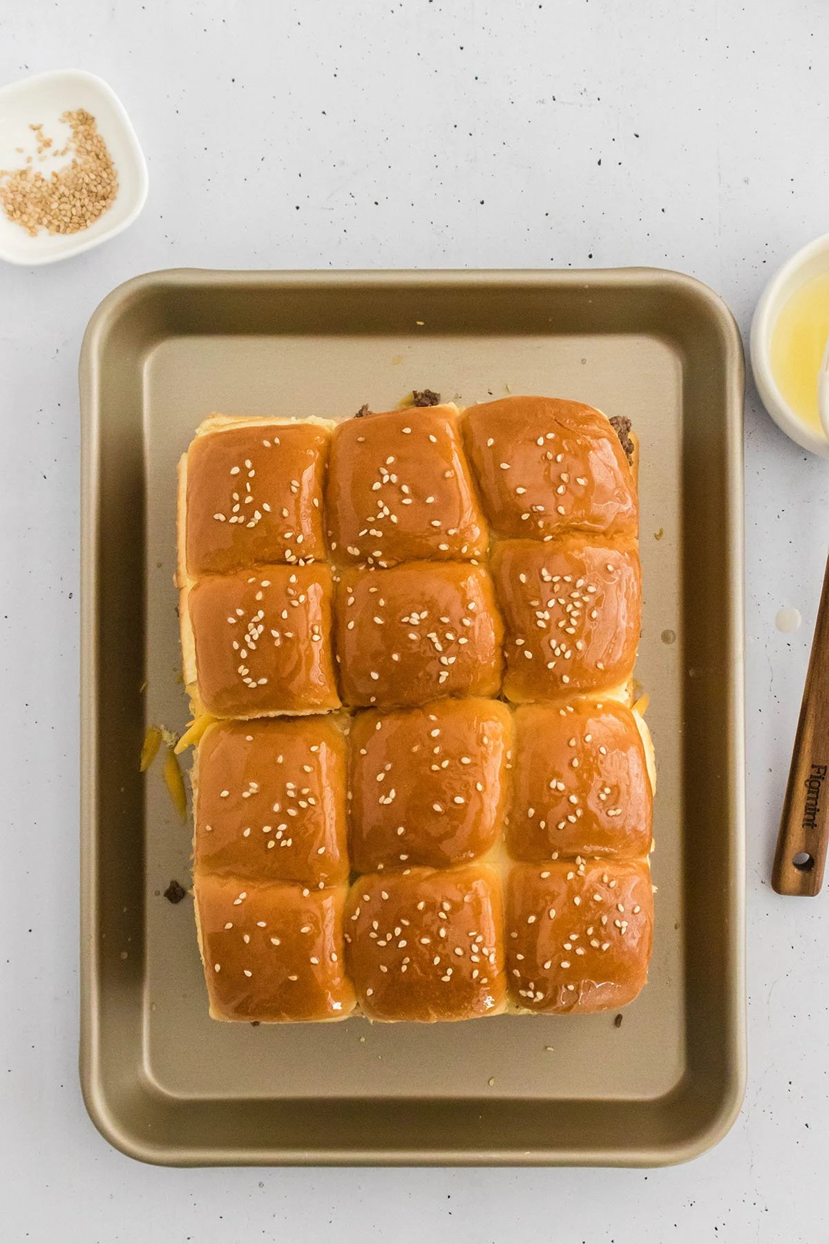 Cheeseburger sliders on a baking pan ready for the oven.