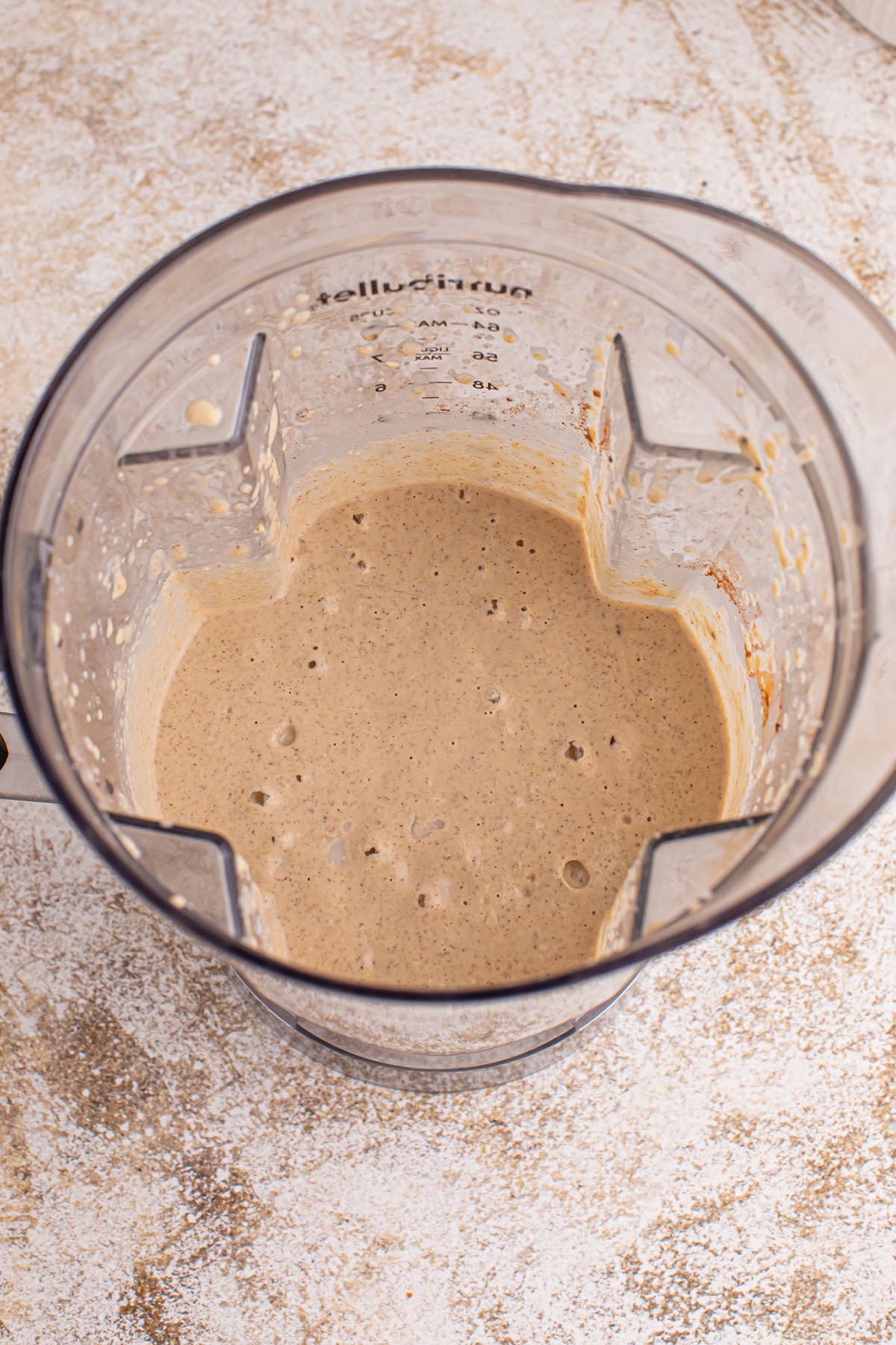 Frozen banana, milk, oats, nuts, nut butter, maple syrup, chia seeds, cinnamon, and vanilla blended together in the blender.