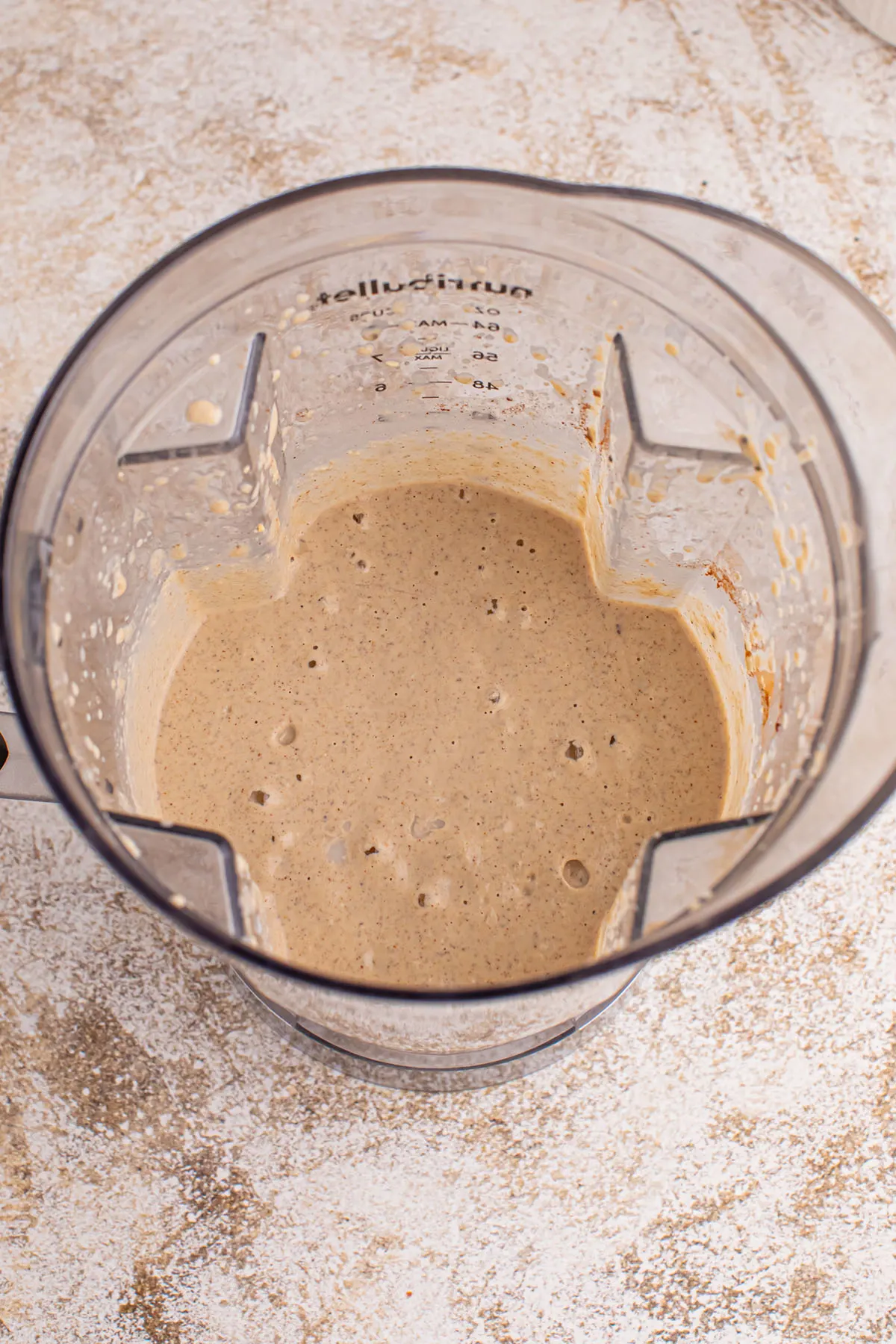 Frozen banana, milk, oats, nuts, nut butter, maple syrup, chia seeds, cinnamon, and vanilla blended together in the blender.