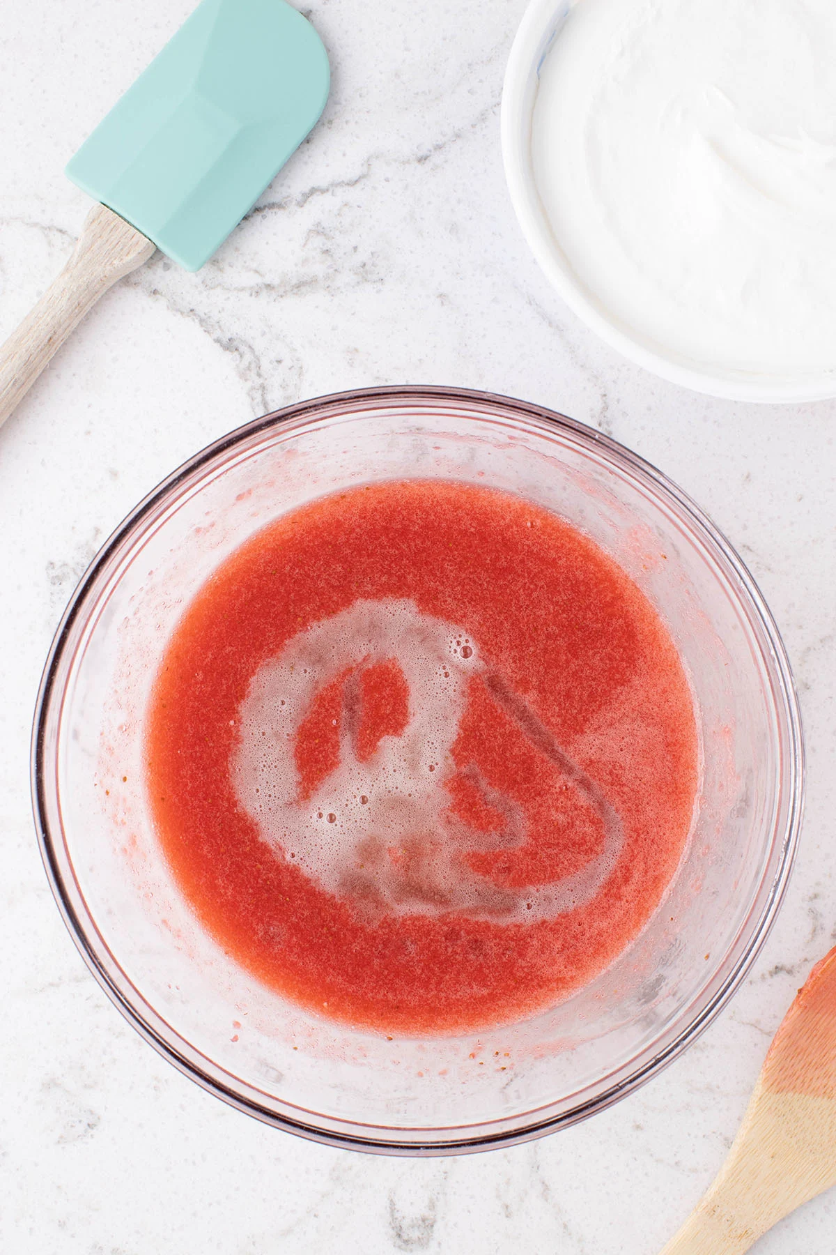Gelatin added to the strawberry mixture in the mixing bowl.