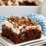 A slice of Reese's Poke Cake on a white plate.